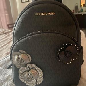 Micheal kors black back pack with flowers on front